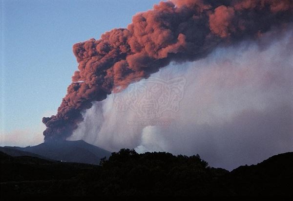 Collezione EM, titolo "Smoke", anno 2001. Etna:inizio  eruzione 2001, esplosione di sabbia vulcanica con evidente ricaduta al suolo, fumo  colorato dalla luce del tramonto, diapositiva  1 / 8 , 30x45, CIBACHROME stampa diretta da diapositiva , 40x55 forex 10mm, perfilo bianco, cartoncino, bordi rivestimento sabbia vulcanica 