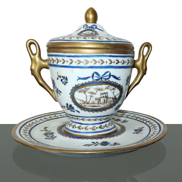 Cup with lid and saucer decorated and glazed in porcelain in shades of blue and manganese with landscapes