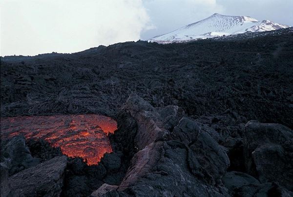 Collection EM, titled "Eruption", year 1998. Etna eruption in 1998, lava string, ingrottamento effusive lava to the mouth, in the background, "the mound" with snow, slide 1/8, 30x45, cibachrome to slide Direct Print, 40x55 forex 10mm, Contouring white, cardboard, cover edges volcanic sand