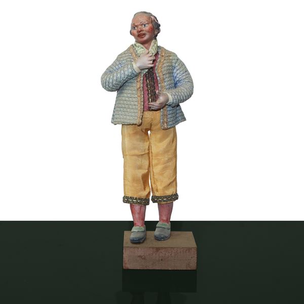 Nativity scene character in terracotta and wood with cotton, satin and trimmings clothes: man with yellow scarf and trousers