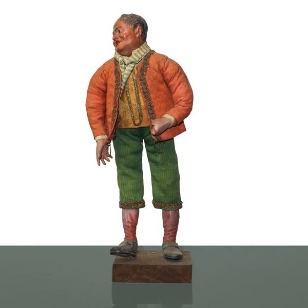 Nativity scene character in terracotta and wood with cotton, satin and trimmings clothes: man with orange jacket and green trousers