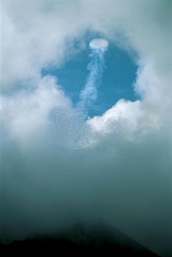 Collection EM, titled "Eyeinthesky (formation of a smokering)", 1999. Etna: Crater South East: formation of a smoke ring, slide 1/8, 30x45, cibachrome slide by direct printing, 40x55 forex 10mm, white Contouring , cardboard, edges coating volcanic sand