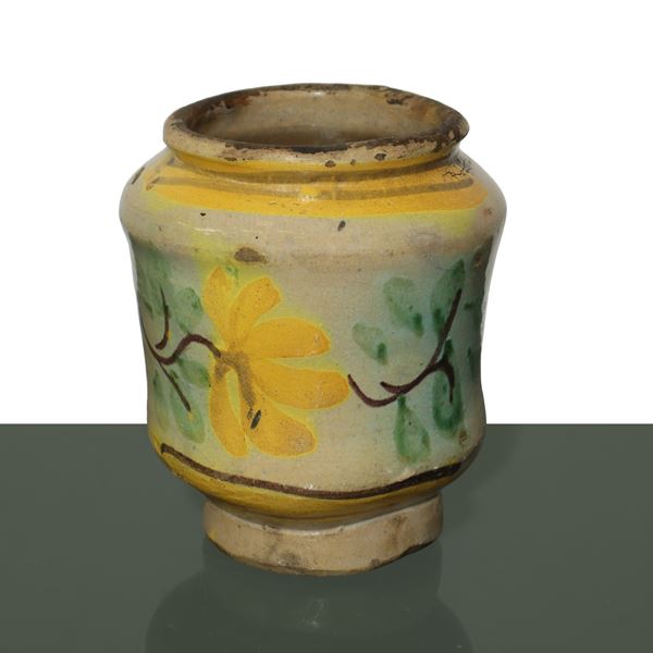 Small cylinder with floral decorations on the front