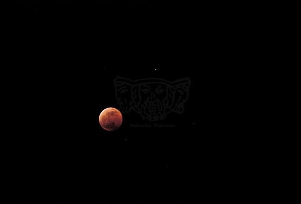 Collection EM, titled "Eclipse", 2001. Catania: lunar eclipse, slide 1/8, 30x45, cibachrome slide by direct printing, 40x55 forex 10mm, Contouring white, cardboard, cover edges volcanic sand