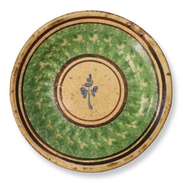 Caltagirone plate sponged green and decorated in the center with a flower