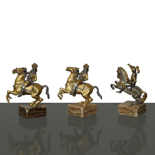 Piero Benzoni - N°3 piccole statue di cavaliere a cavallo  in bronzo argentato e dorato montate su base in onice 