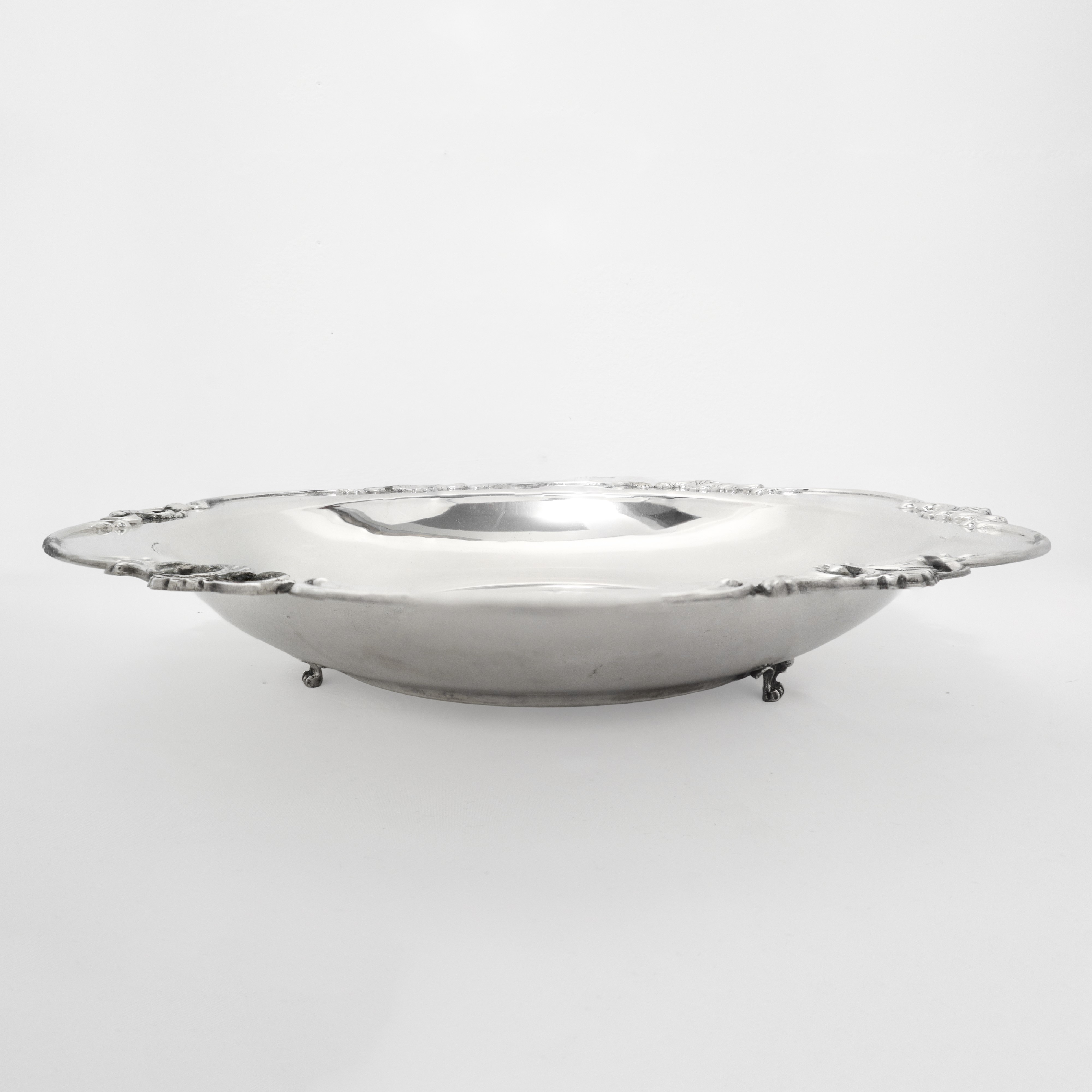 Portadolci in argento 800 con bordo smerlato e piedi di sostegno decorati