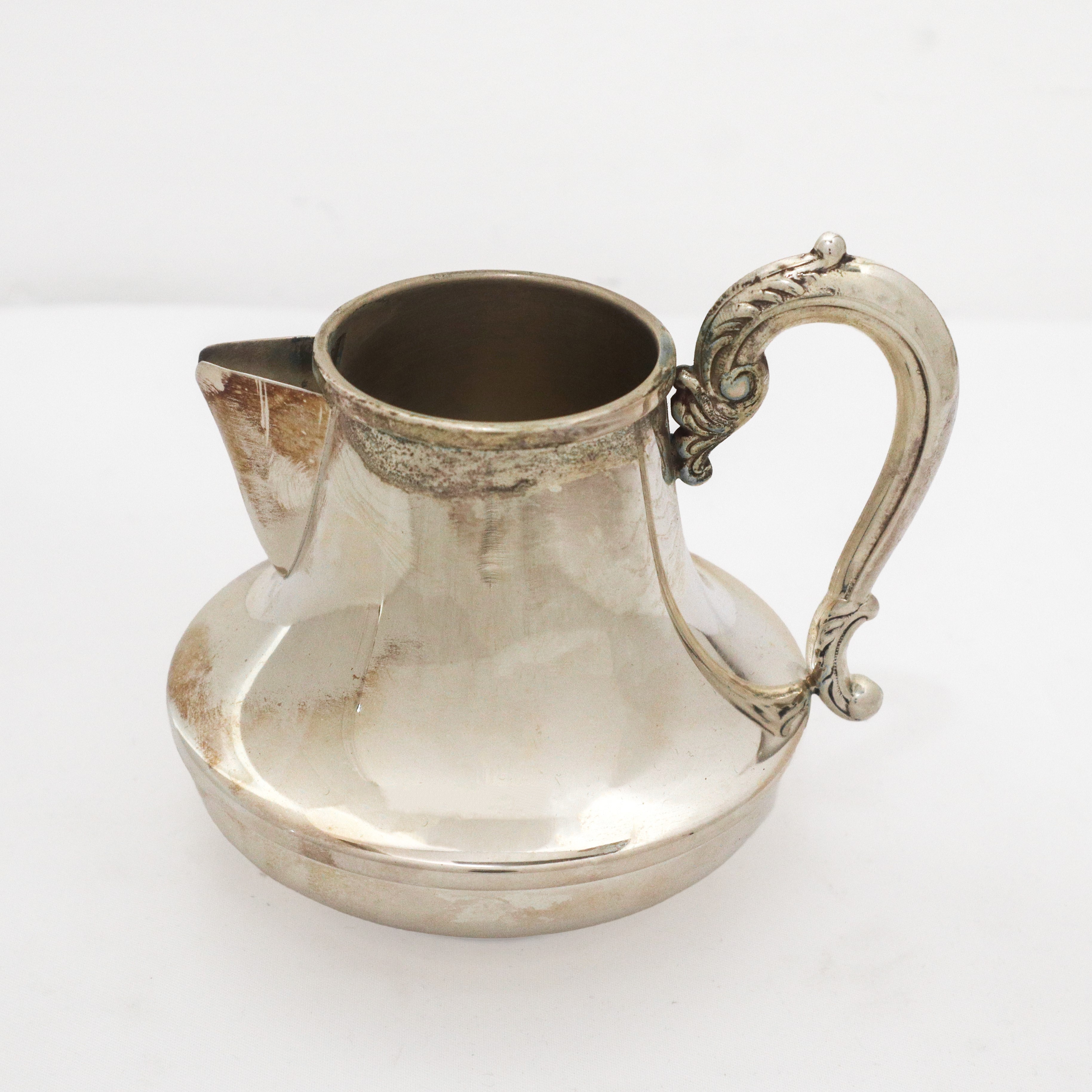 Servizio da tè e caffè in argento 800 con pigne sul coperchio e prese decorate