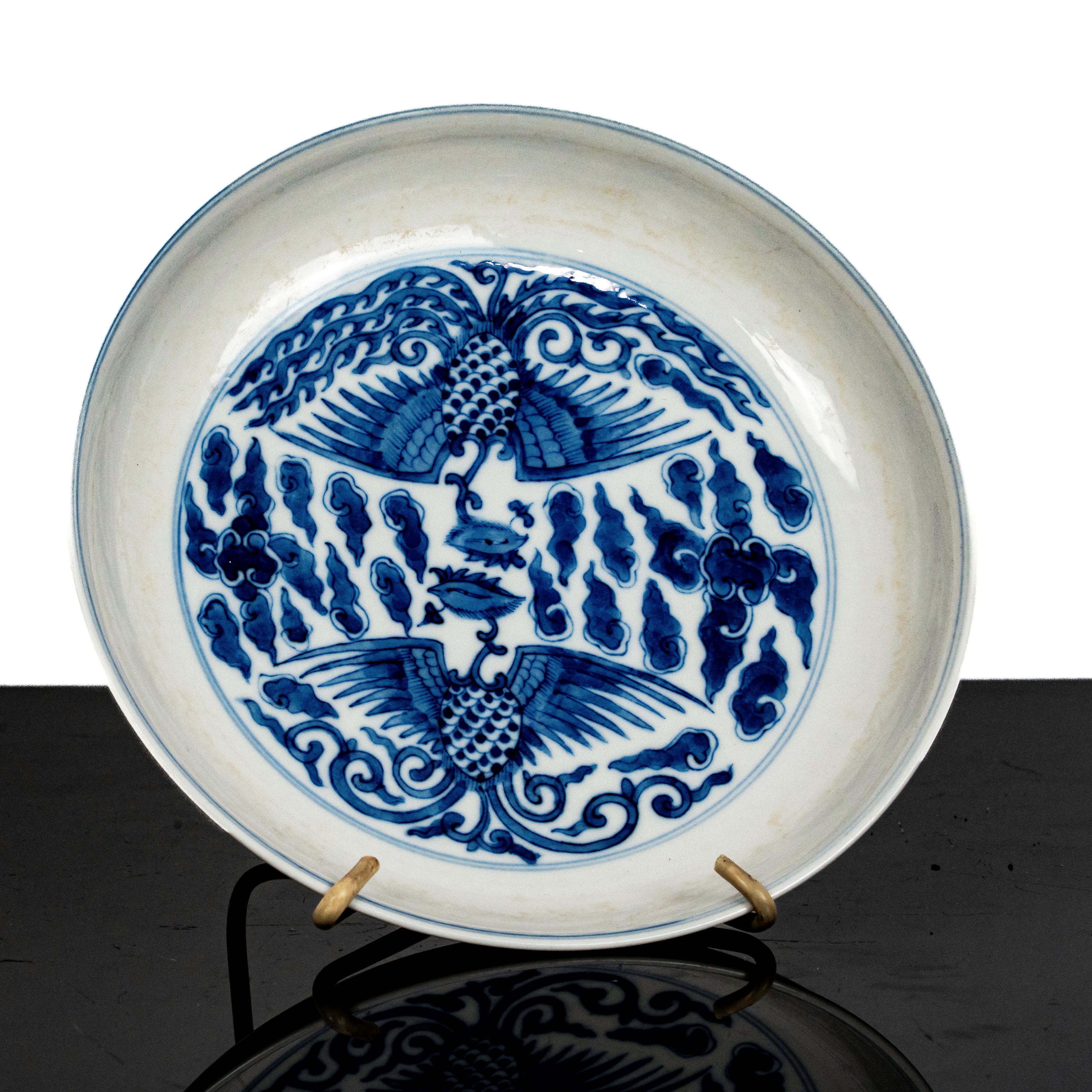 Piatto in porcellana bianca e blu con decori di fenici