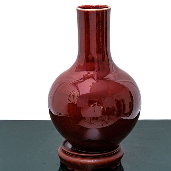Oxblood red vase with wooden base
