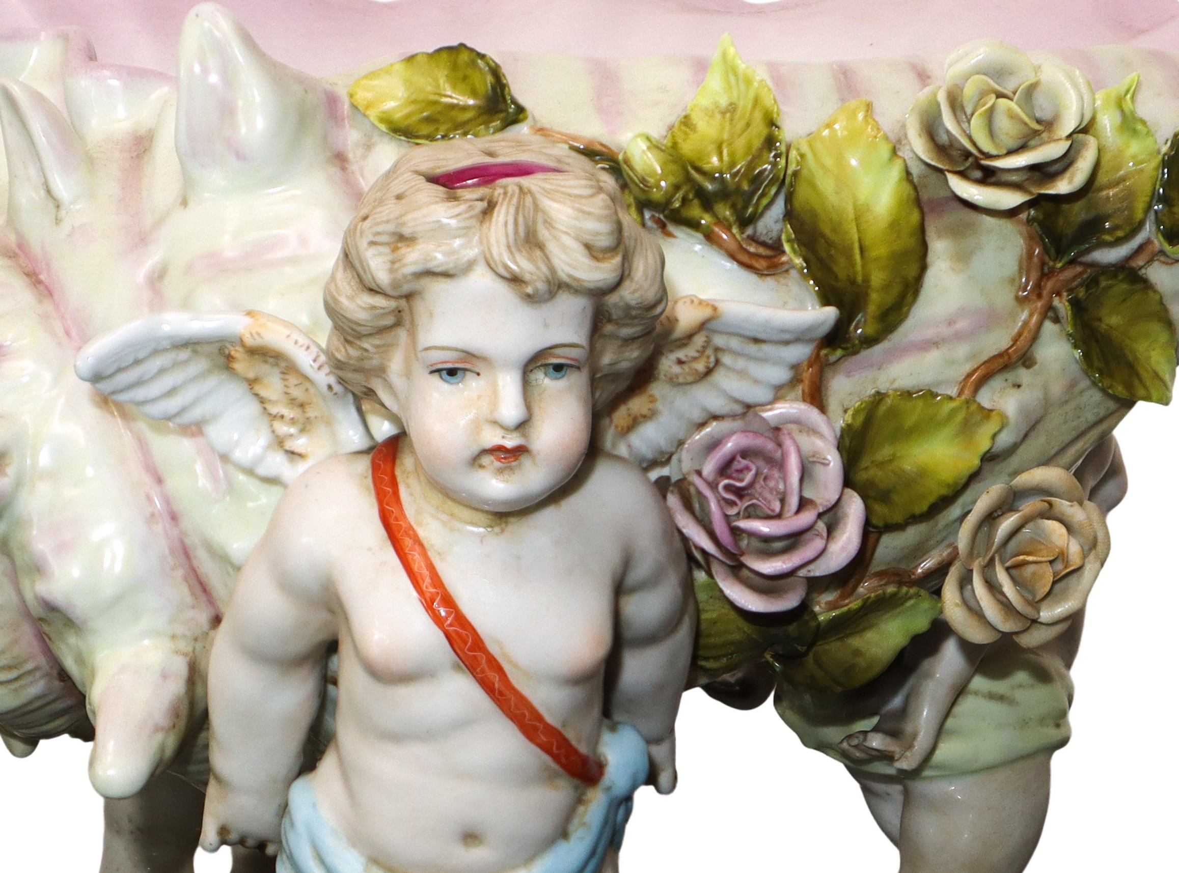 Centrotavola a conchiglia retto da tre putti alati in porcellana policroma