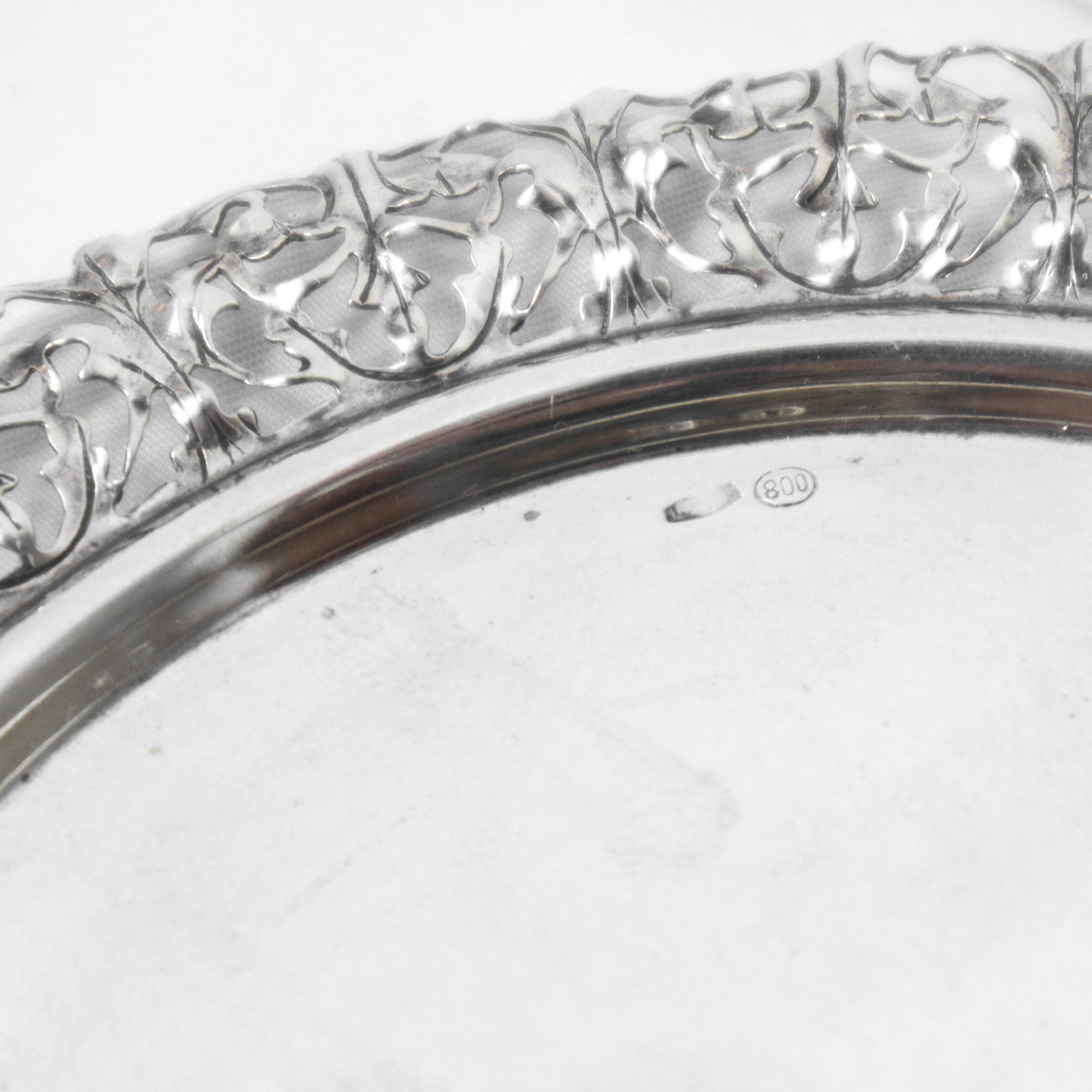 Portabottiglie e alzata rotondi in argento 800 con bordo filigranato