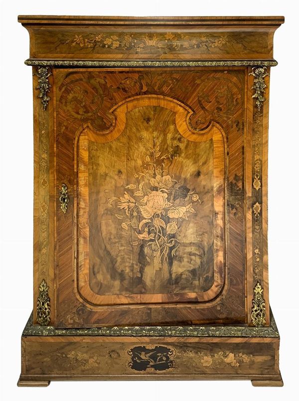 Piccola credenza bassa ad un'anta, Francia , inizi XIX secolo. Intarsi floreali sul fronte, piano in radica d’ulivo entro riserve in bois de rose. Inserti e cornici in metallo dorato. H cm 116x80x35