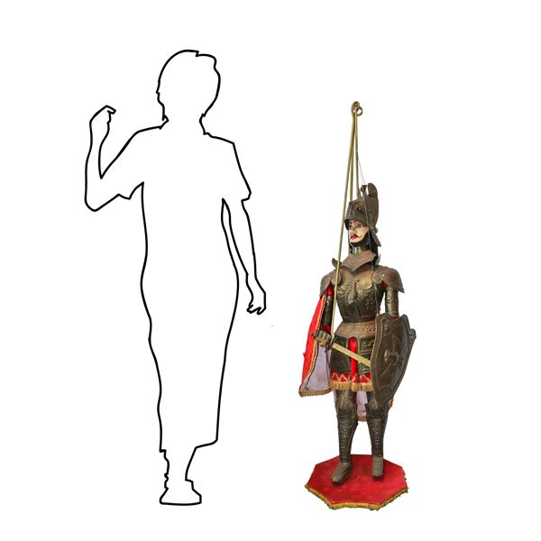 Sicilian puppet with bronzed metal armor and red clothes and cloak