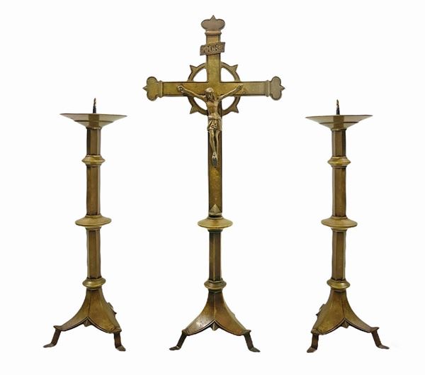 Trittico in bronzo dorato composto da Cristo in croce e coppia di candelabri, XIX secolo. In stile tardo gotico. H croce cm 57, candelabro cm 40.