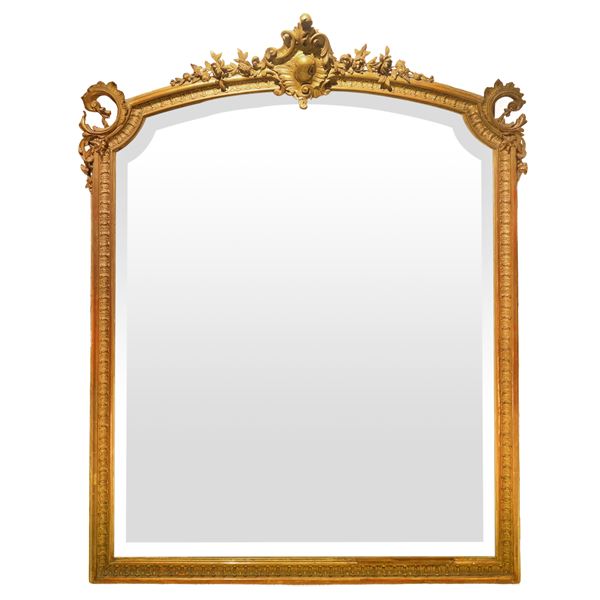 Grande specchio con cornice in  legno dorato con cimasa centrale intagliata e scolpita 