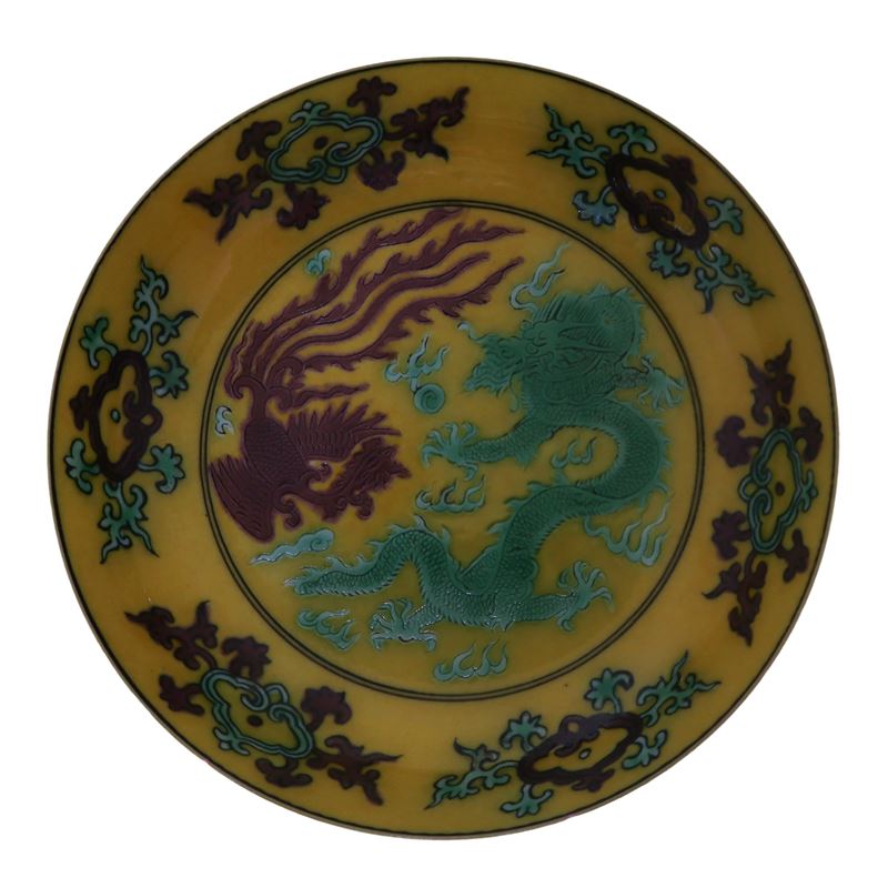 Piatto fondo giallo con raffigurazioni di drago e fenice nei toni verde e marrone
