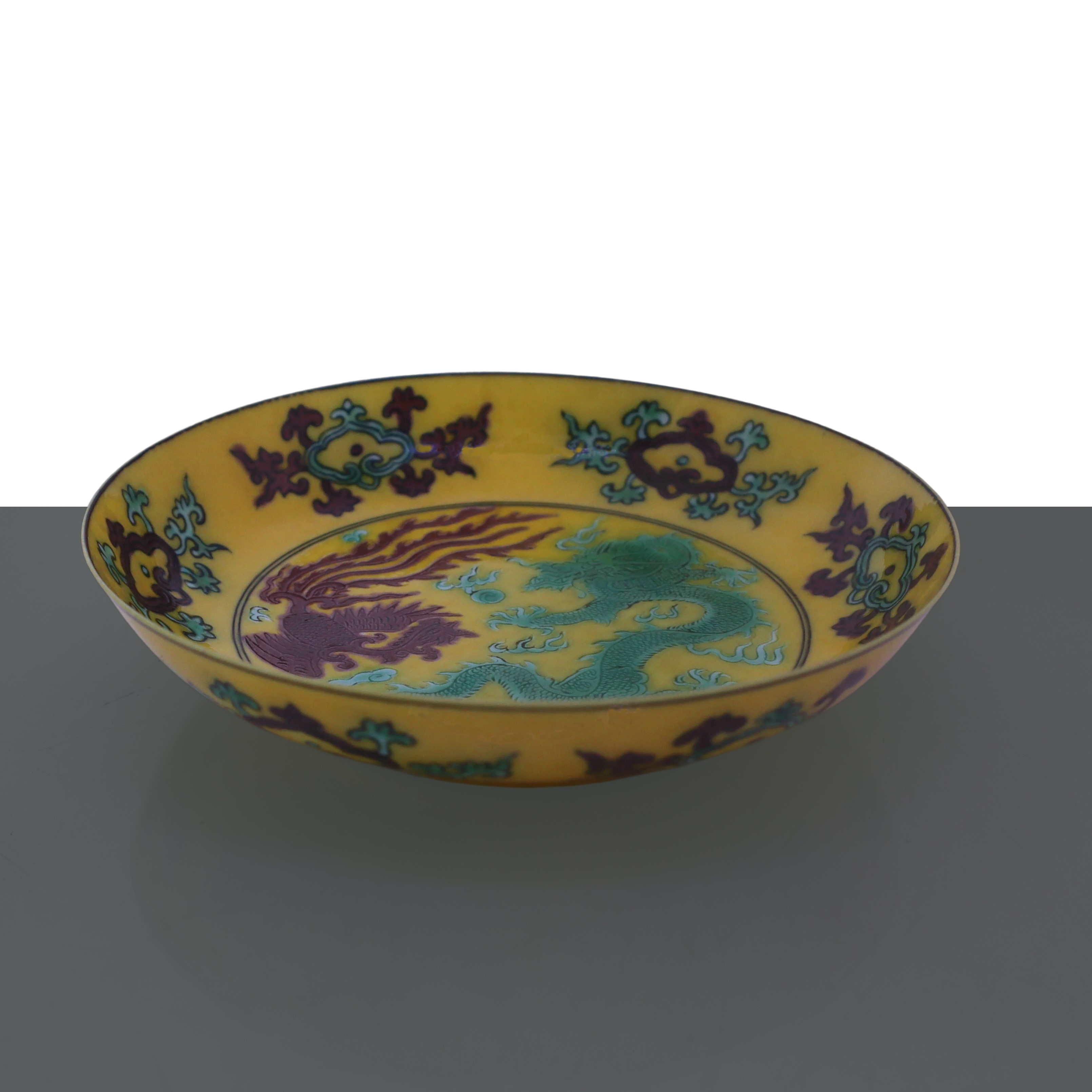 Piatto fondo giallo con raffigurazioni di drago e fenice nei toni verde e marrone