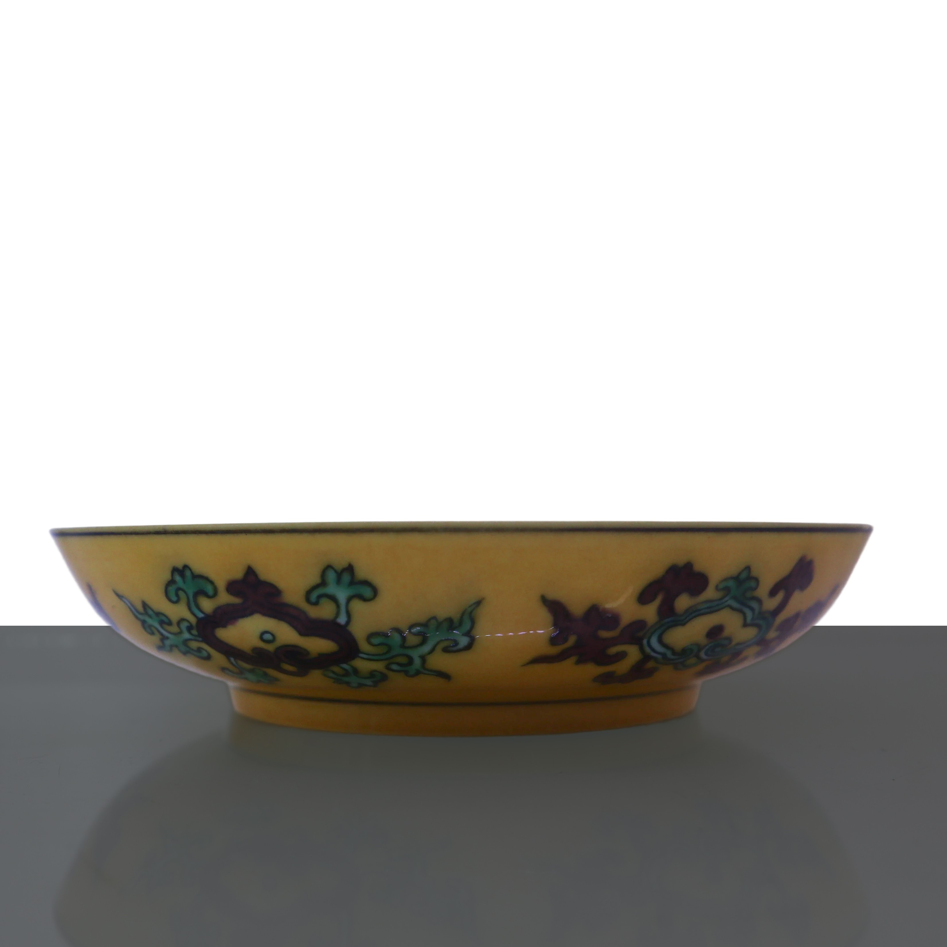 Piatto fondo giallo con raffigurazioni di drago e fenice nei toni verde e marrone
