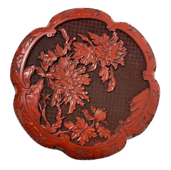Scatola laccata in rosso cinabro. Decorazione floreale a basso rilievo. 
Diametro cm 25, h cm 5,5