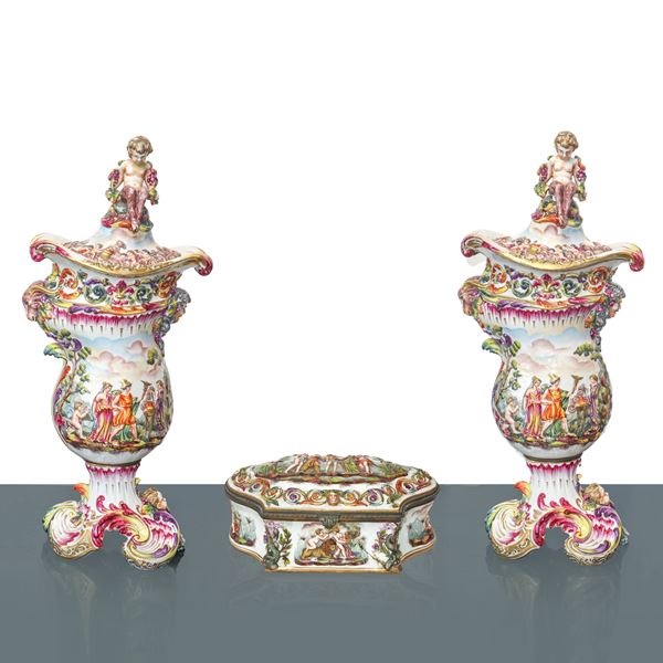 Pair of Capodimonte vases decorated in relief with cherubs on the top and a chest