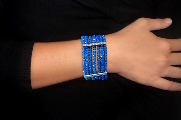 585 (14 KT) gold band bracelet with garnets and stones on the strap and along the 3 support bands that space out the 7 rows of sapphire paste grains