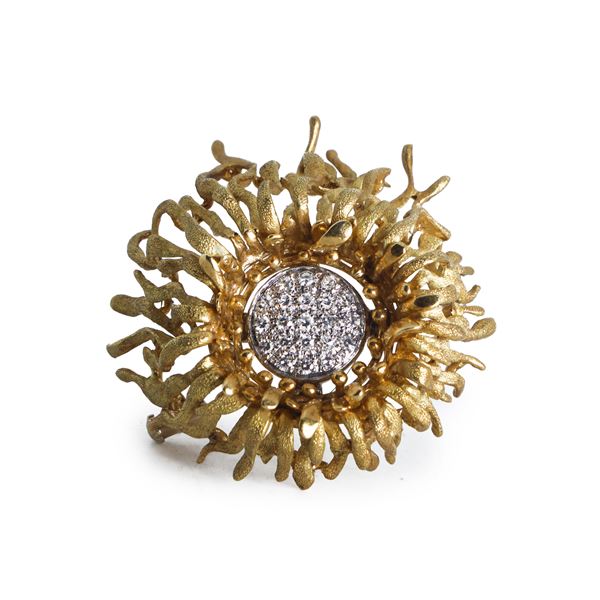 Satin gold brooch in the shape of a flower with the corolla decorated with brilliant-cut diamonds