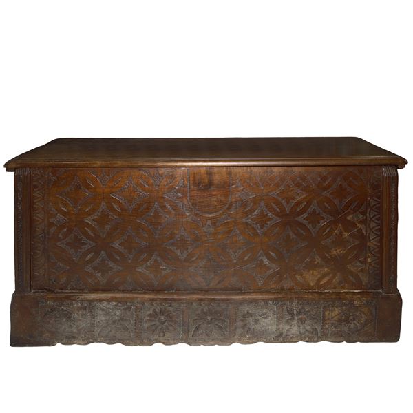 Cassapanca sarda campidanese in legno di noce sul fronte e sui lati bulinata e intagliata a motivi vegetali, lateralmente lesene scolpite e ala base dei lati grandi losanghe
