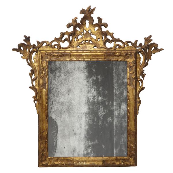 Gilded wood mirror with leaf decoration and a frieze at the top