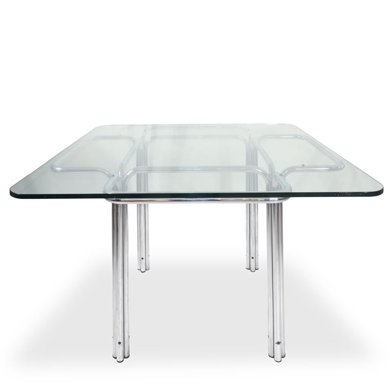 Tavolo modello Topos con struttura in metallo cromato argentato che partendo da terra si apre com...