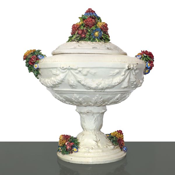 Centrotavola in ceramica di Bassano con ricco rilievo floreale sul coperchio e sui bordi, modellato a larghe foglie alla base e ricche ghirlande nella parte più ampia del fusto