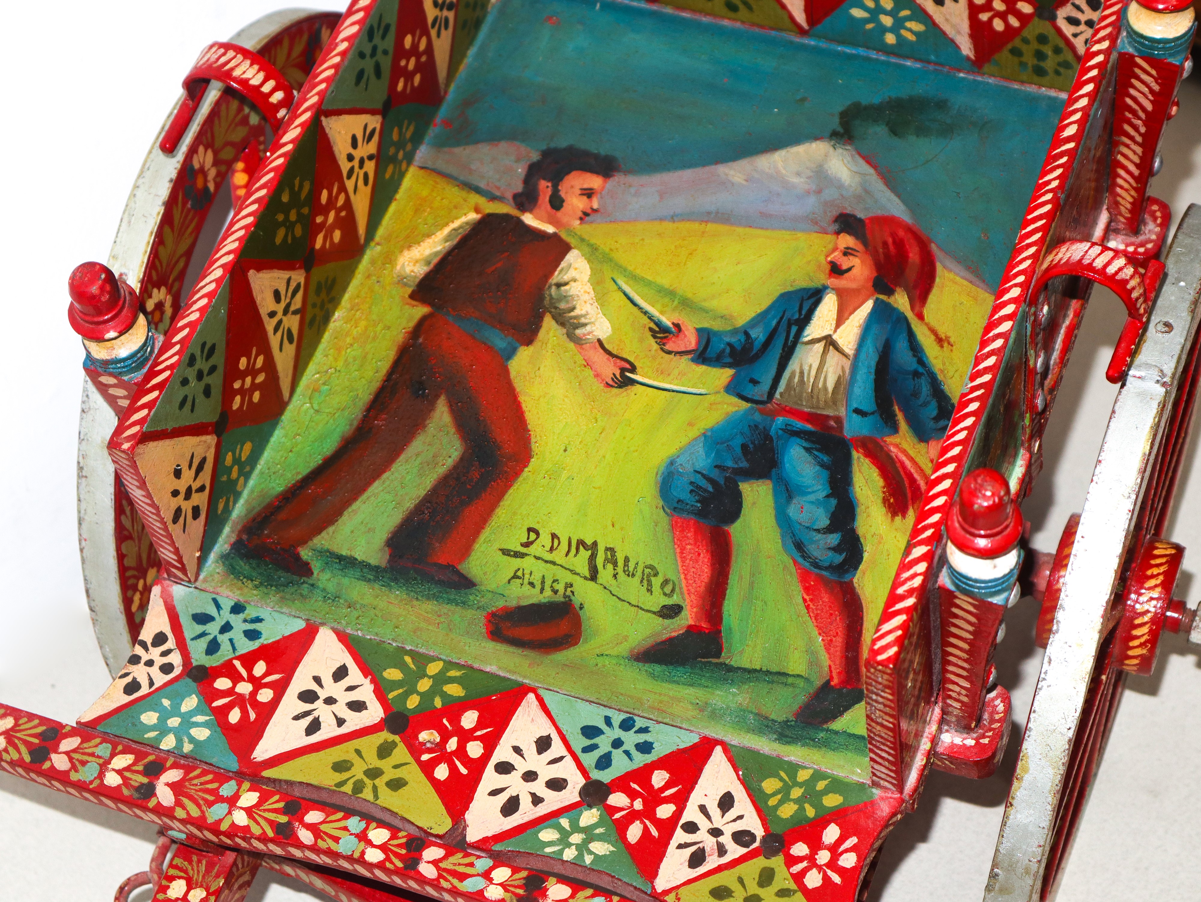 Piccolo carretto siciliano in legno dipinto policromo con Etna e scena di combattimento