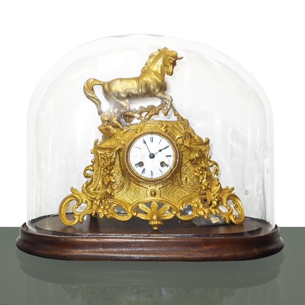Gold-plated metal clock in glass case with white porcelain dial