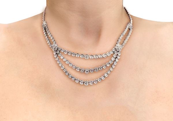 18kt white gold necklace with three rows of brilliant-cut diamonds and flower-shaped decorations.