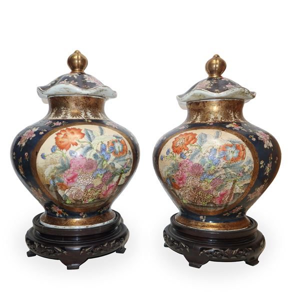 Pair of Chinese poutiche painted in polychrome on a black background with a wooden base