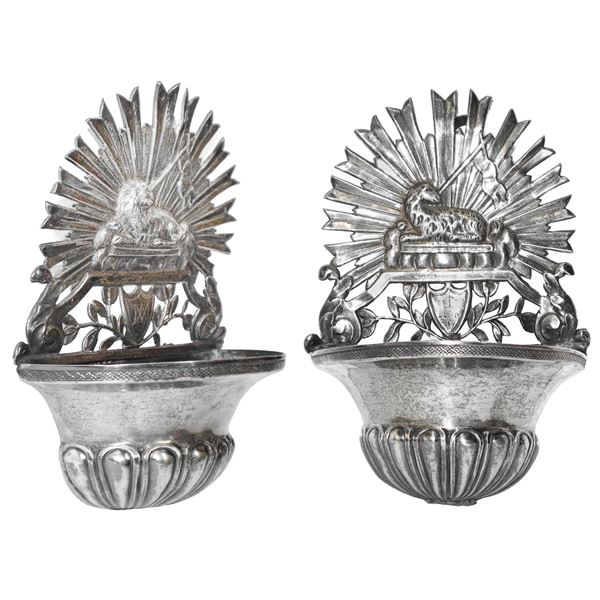 Pair of small silver holy water stoups with a halo and lamb at the top