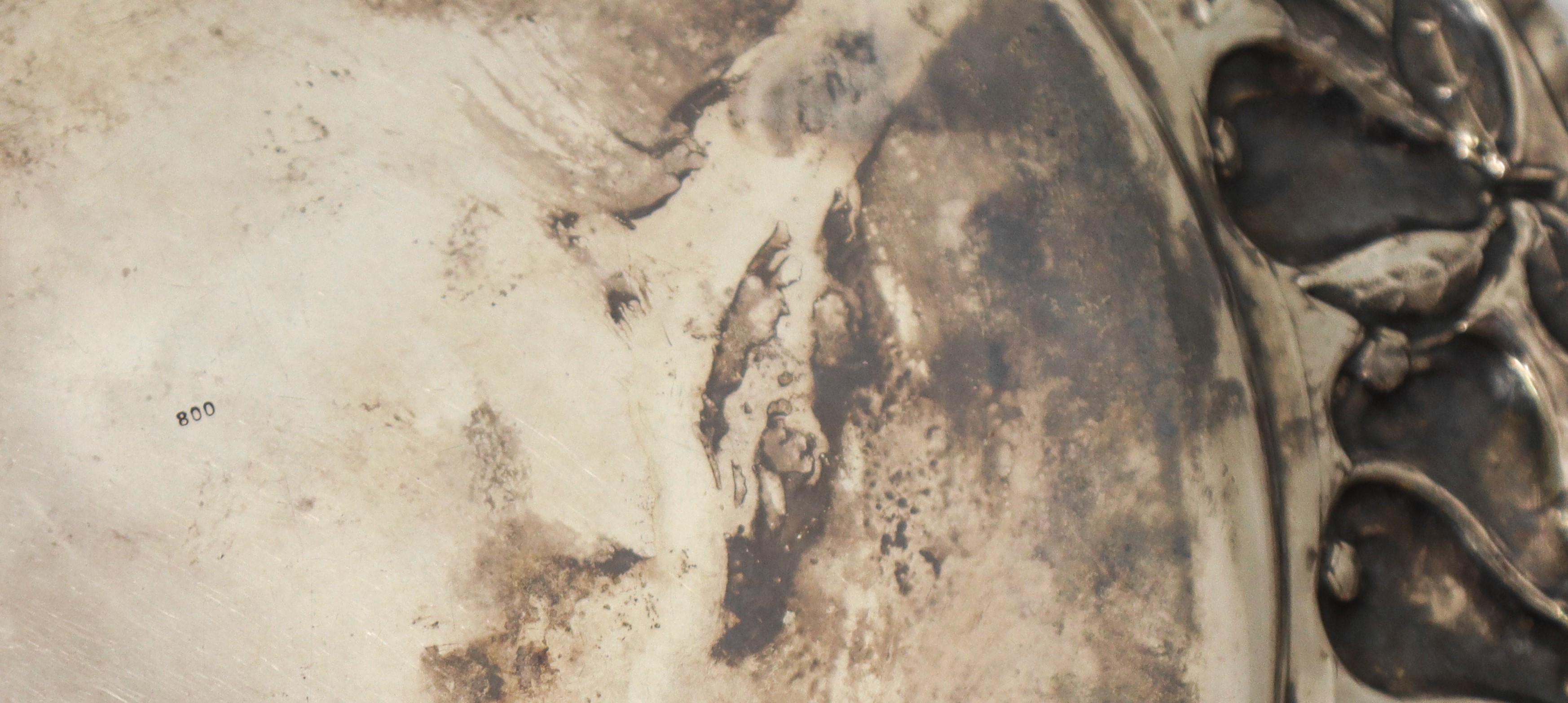 Piatto centrotavola in argento 800 con decorazioni a sbalzo di melagrane lungo il bordo lungo il ...