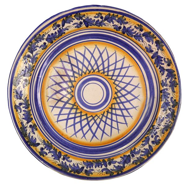 Piatto in maiolica di Santo Stefano di Camastra dipinto policromo nei toni del blu e dell'arancione con decoro di foglie sul bordo
