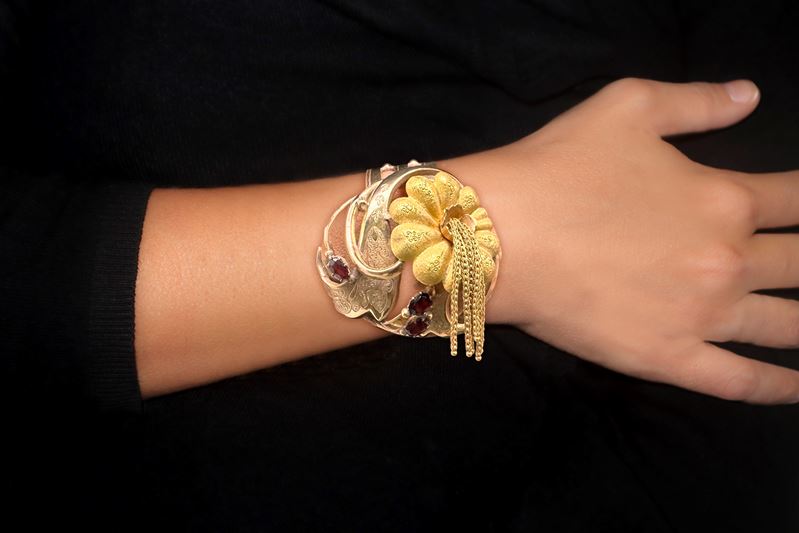 Bracciale in oro basso titolo con decoro a guisa di fiore con granati e filigrana