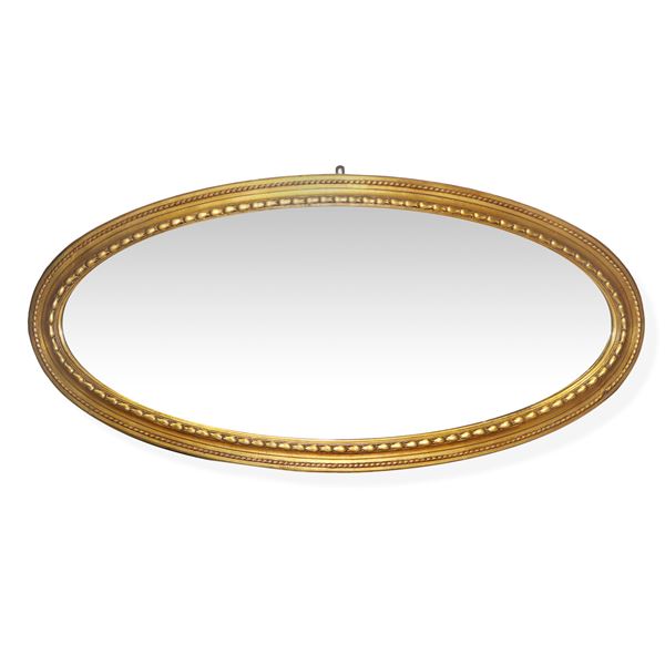Grande specchiera ovale in cornice dorata