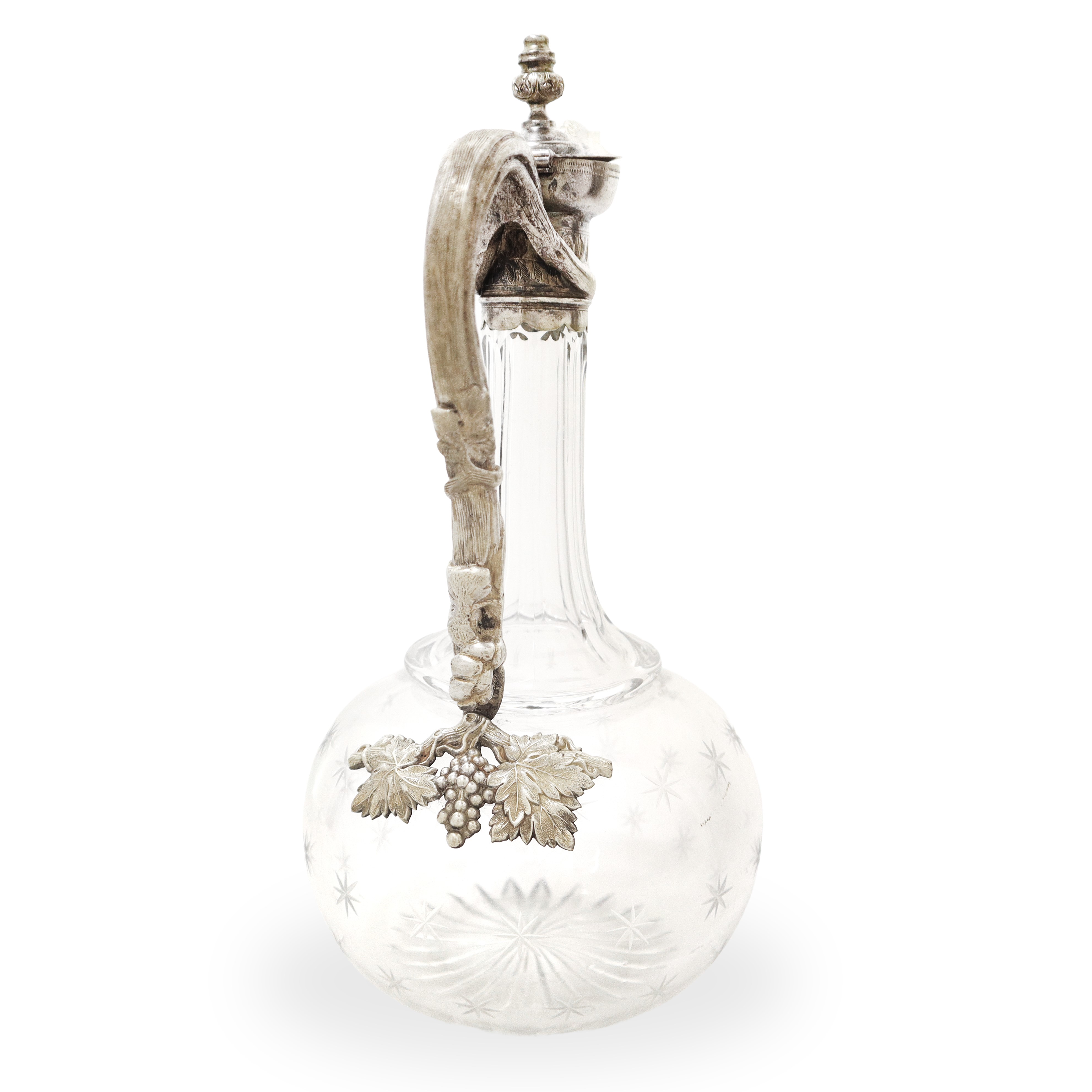 Caraffa in vetro molato con manico in metallo decorato con tralci d'uva