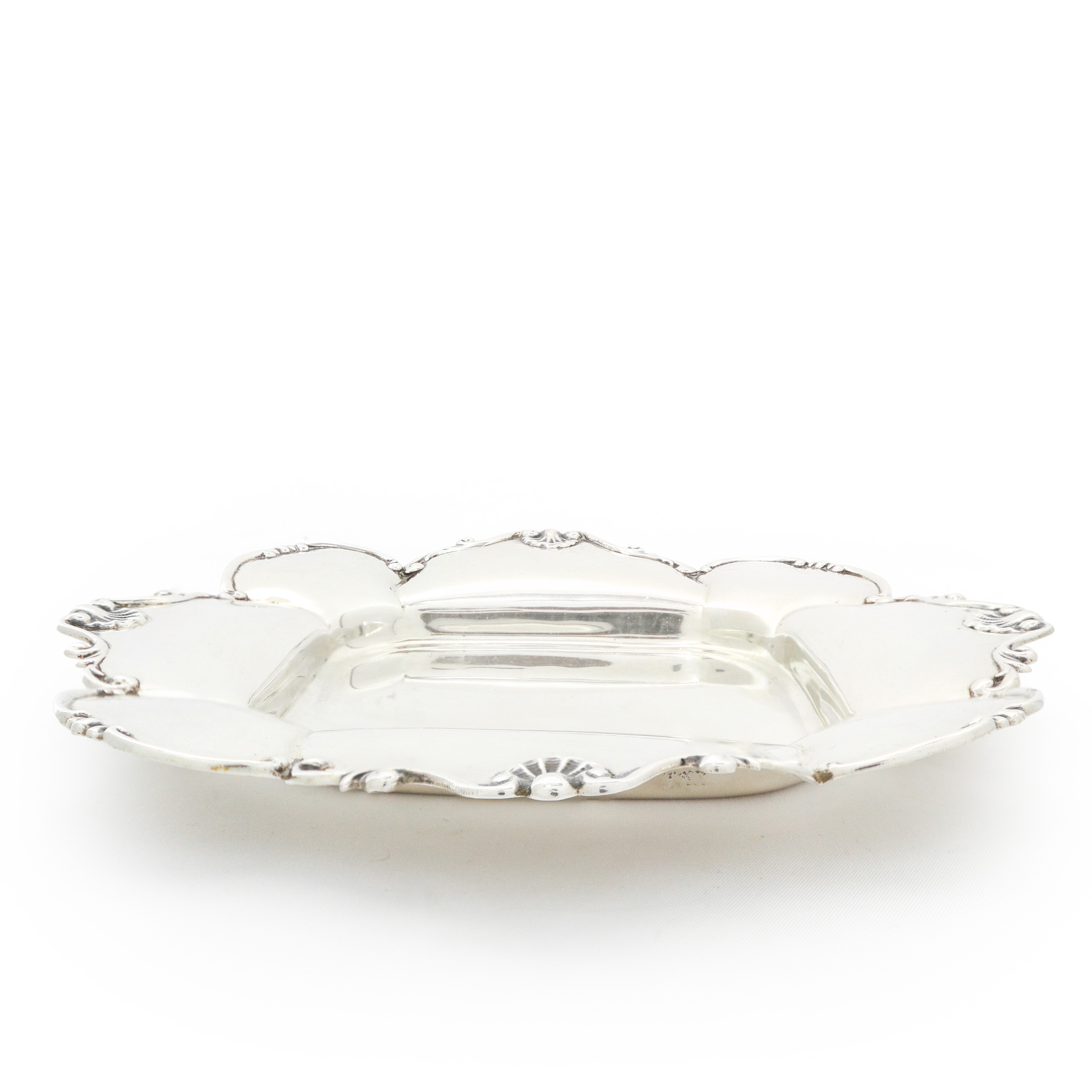 Piattino svuotatasche in argento 800 con bordi smerlati e decorati con conchiglie a rilievo