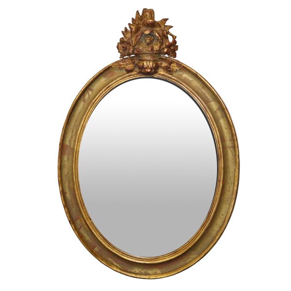 Oval gilded wooden mirror with cymatium