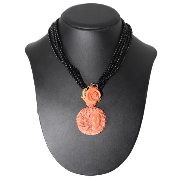 Onyx necklace with a central coral pendant depicting a woman with a flowered head and roses