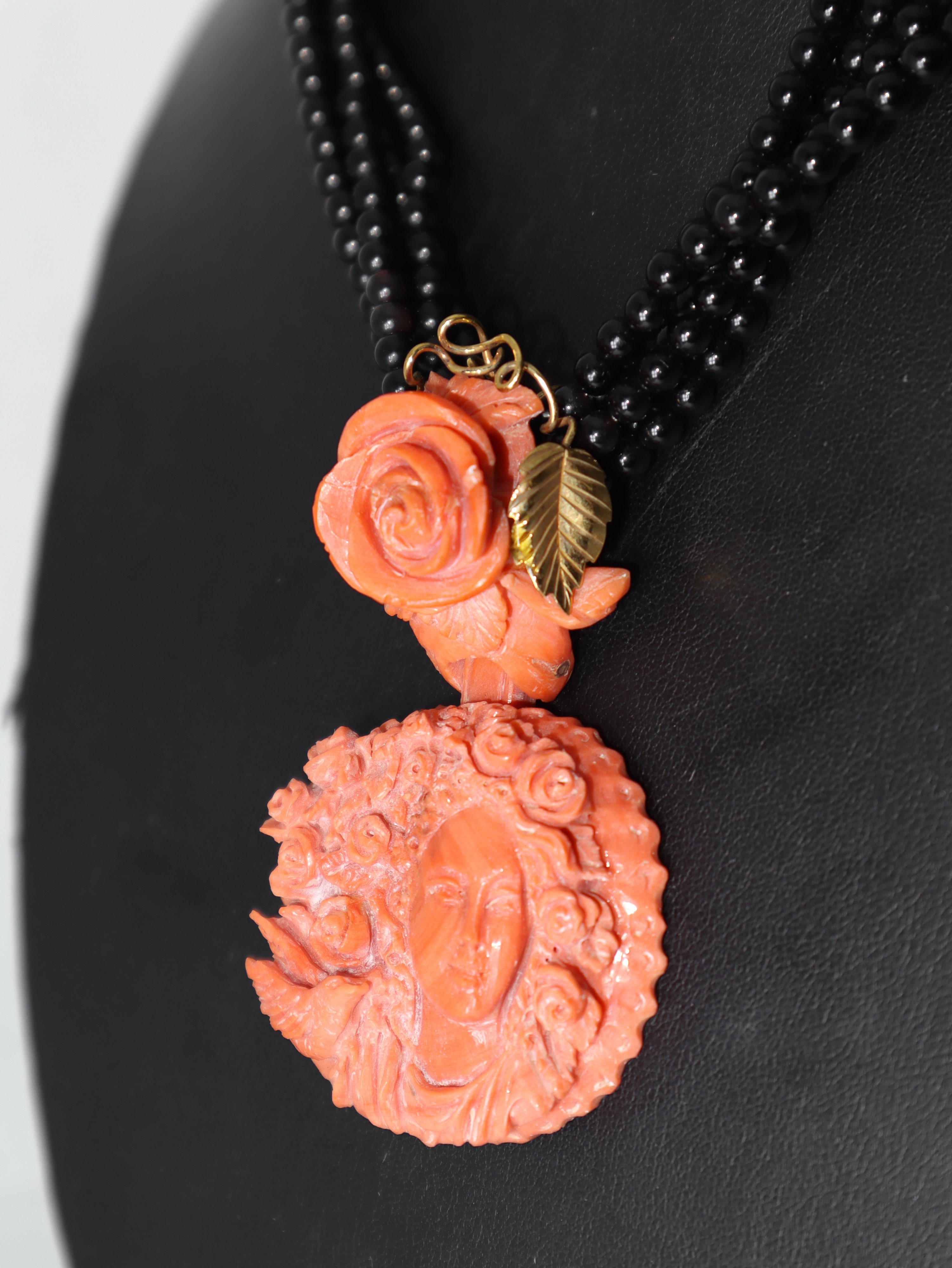 Collana in onice con pendente centrale in corallo raffigurante donna con testa fiorita e rose