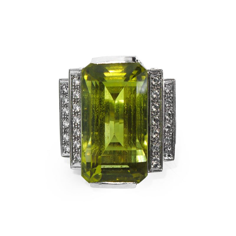 Anello da cocktail in oro bianco con corindone centrale affiancato da una doppia fila di brillant...