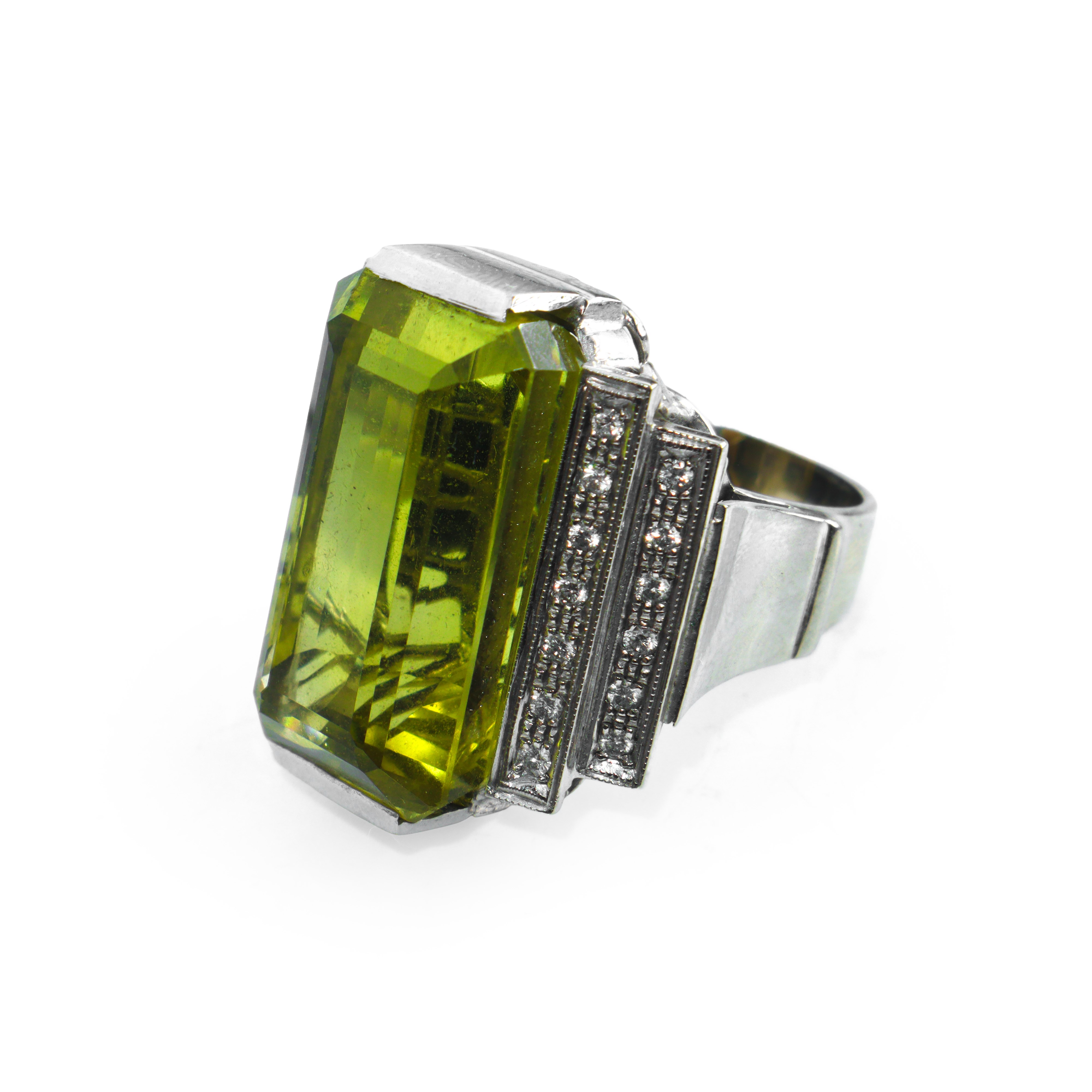 Anello da cocktail in oro bianco con corindone centrale affiancato da una doppia fila di brillant...