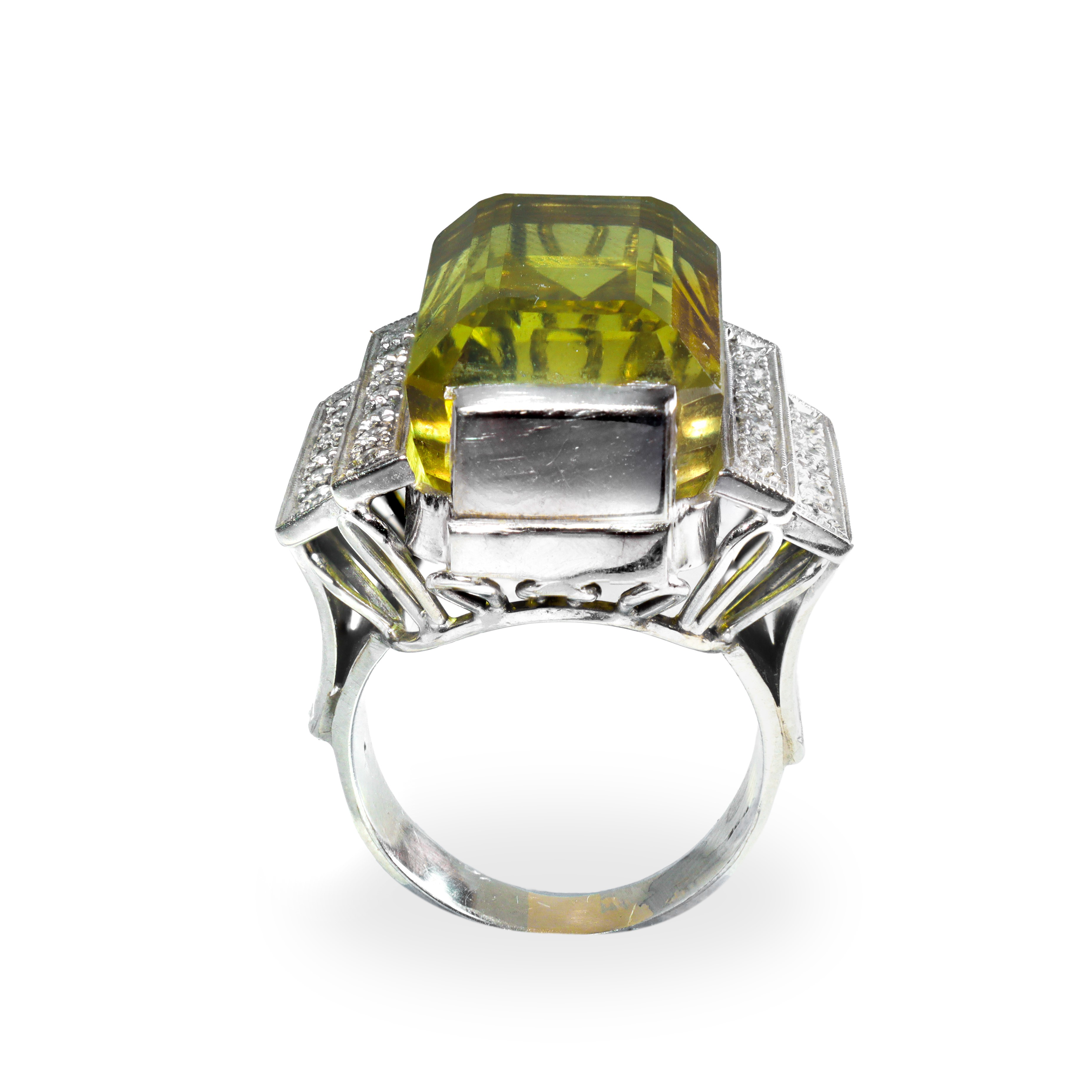 Anello da cocktail in oro bianco con corindone centrale affiancato da una doppia fila di brillant...