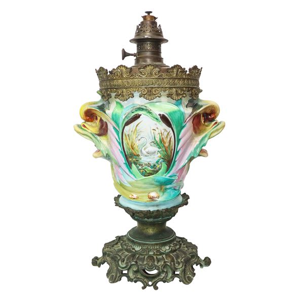 Lume a petrolio con con medaglioni con decori e prese laterali a bocche di pesce