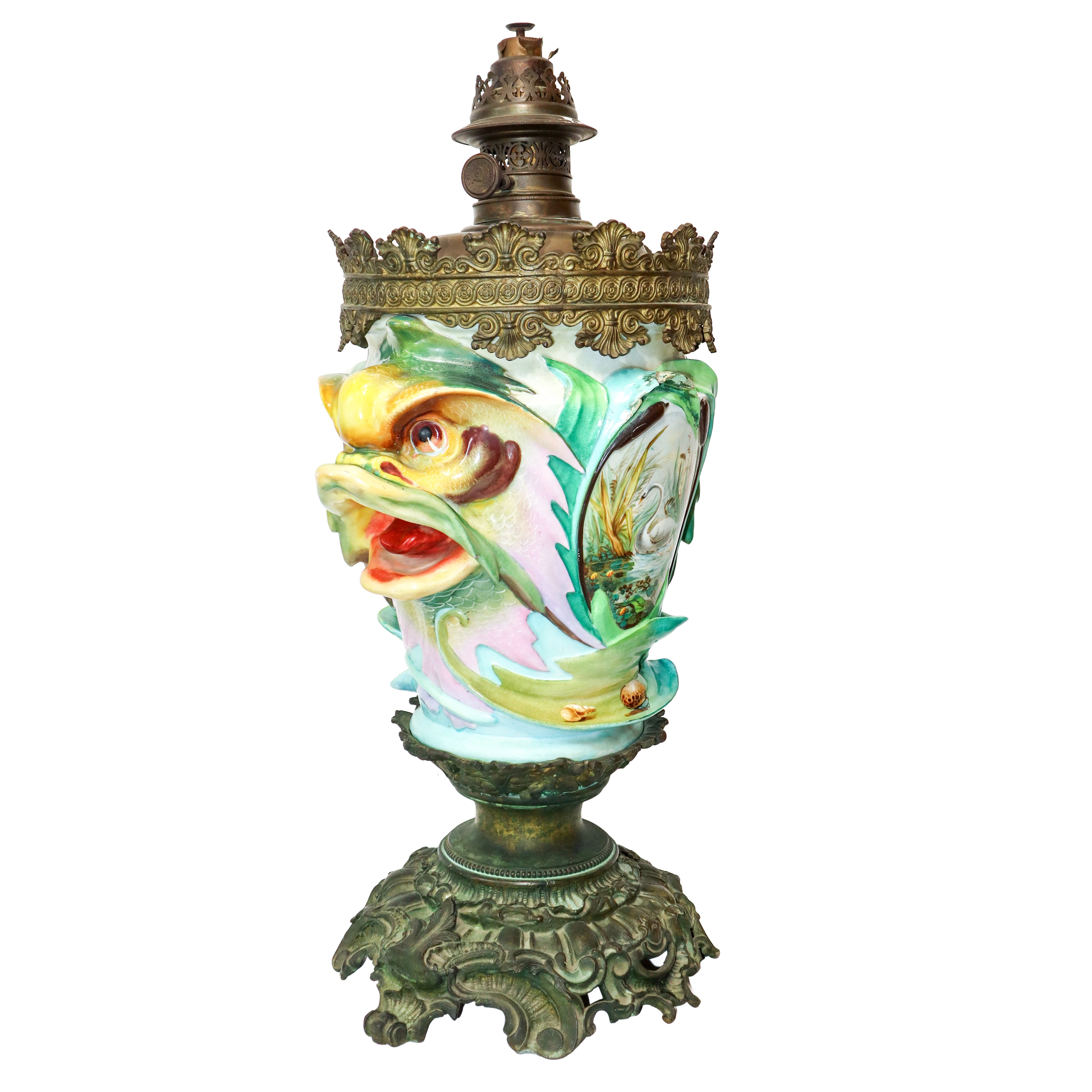 Lume a petrolio con con medaglioni con decori e prese laterali a bocche di pesce